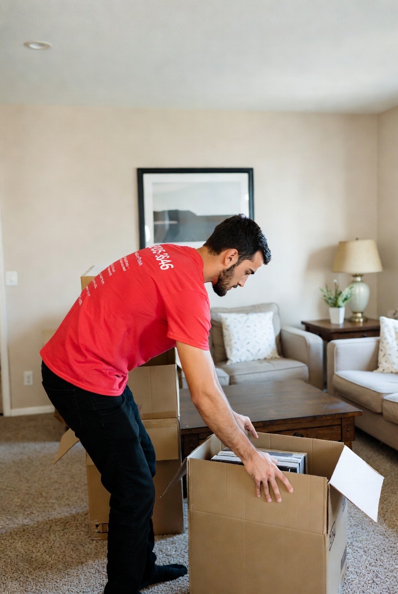 Mover reviewing and organizing items into a box during in-home estimate